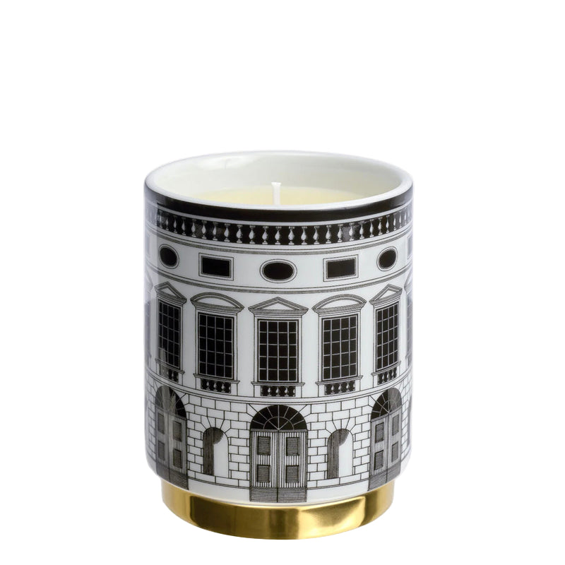 Candle in a decorative container with architectural design on a white background