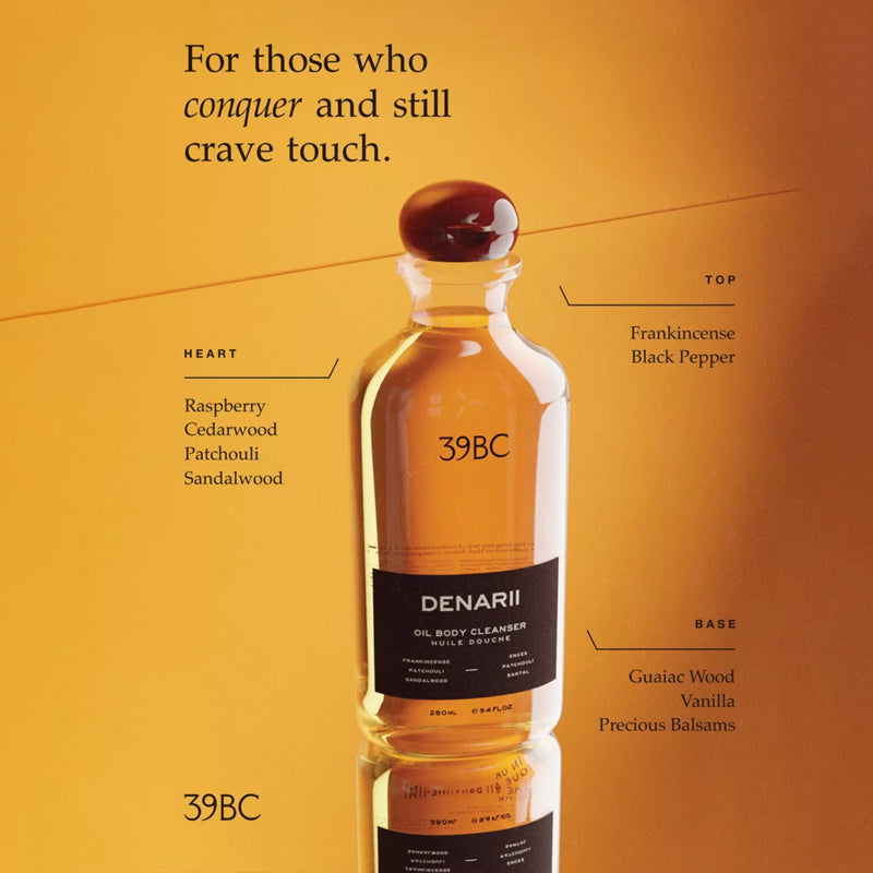 Bottle of Denarii oil body cleanser with product details on an orange background