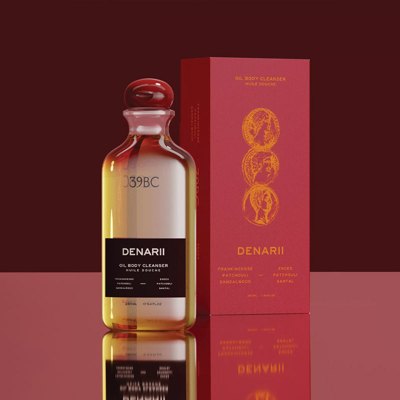 Denarii oil body cleanser bottle with packaging on a red background