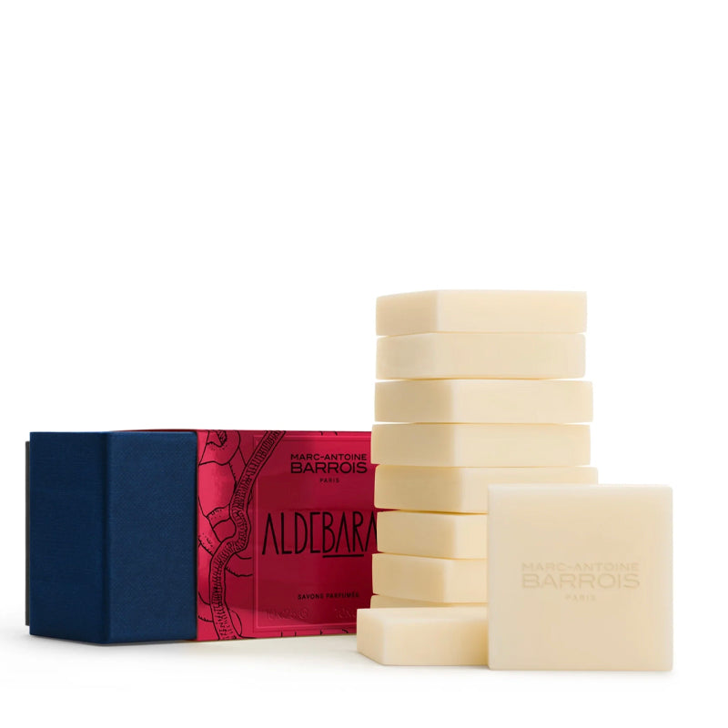 A set of ten pale cream-colored rectangular guest soap bars of Marc Antoine Barois Aldebaran scent, alongside their blue and red packaging box on a white background.