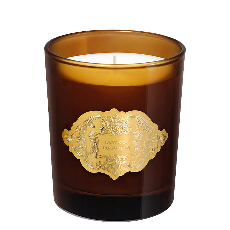 Brown candle by L'Artisan Parfumeur with a gold label on a white background