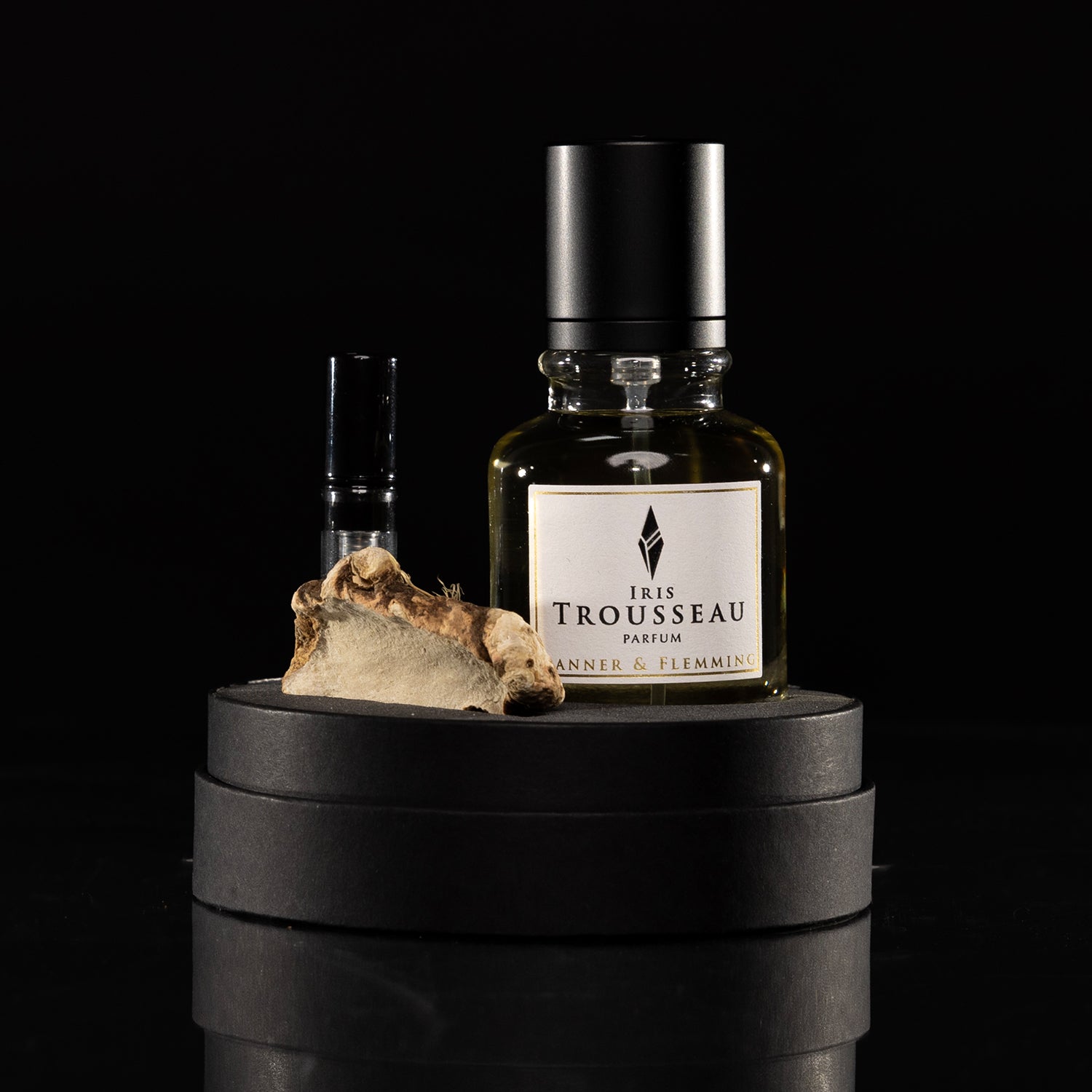 Perfume bottle labeled 'Iris Trousseau' on a black background. Iris Trousseau Millésime Parfum • Selection 2026 | Danner & Flemming | AEDES.COM