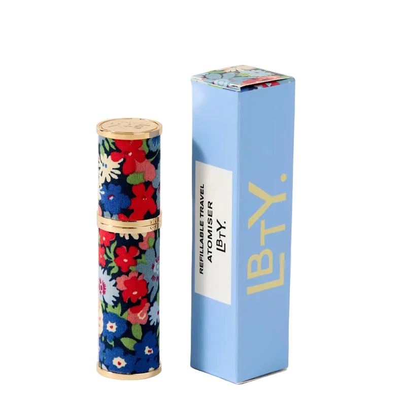 Floral-patterned cylindrical Travel atomizer by Liberty Beauty with gold accents on a white background
