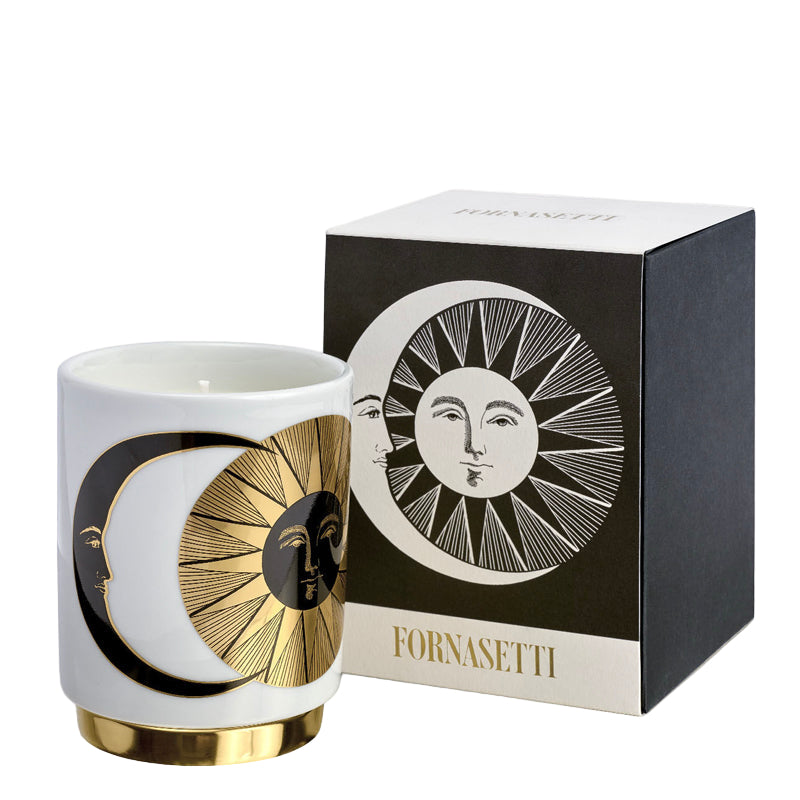 Fornasetti candle with decorative design and matching box on a white background