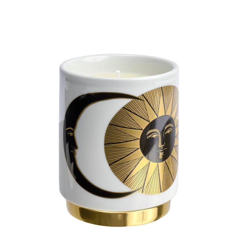 Candle in a white container with gold and black design on a white background