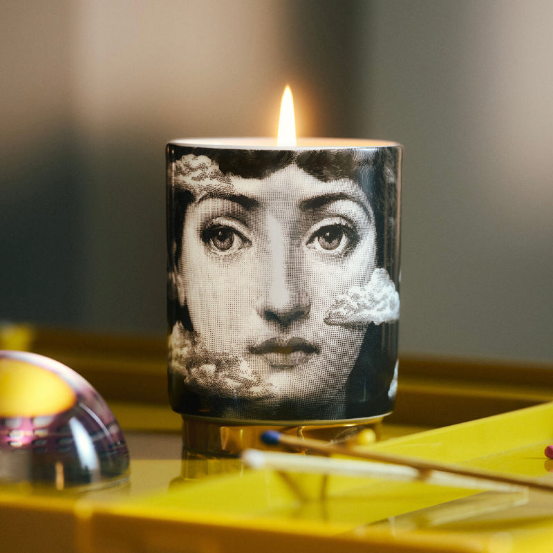 Candle with a face design on a reflective surface