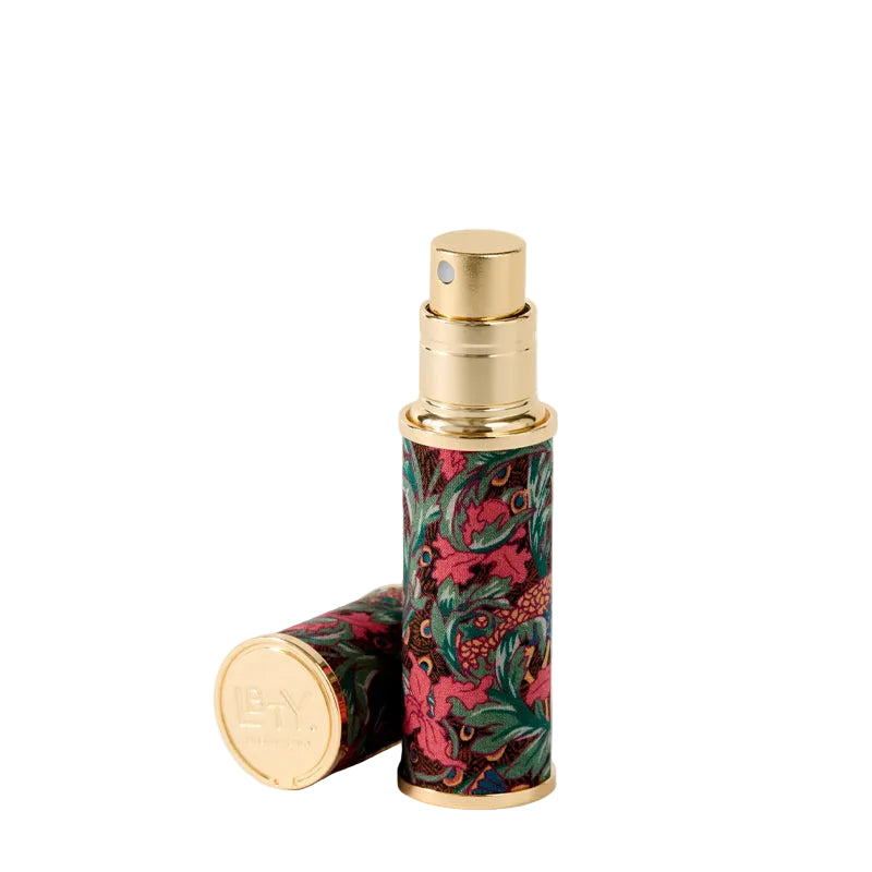 Decorative cylindrical travel atomizer by Liberty London with floral pattern on a white background