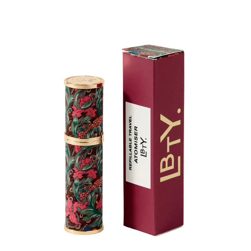 Decorative cylindrical travel atomizer by Liberty London with floral pattern on a white background