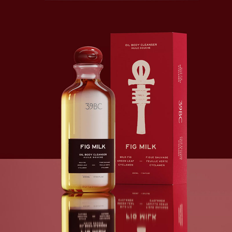 Bottle of Fig Milk oil body cleanser with red packaging on a reflective surface.