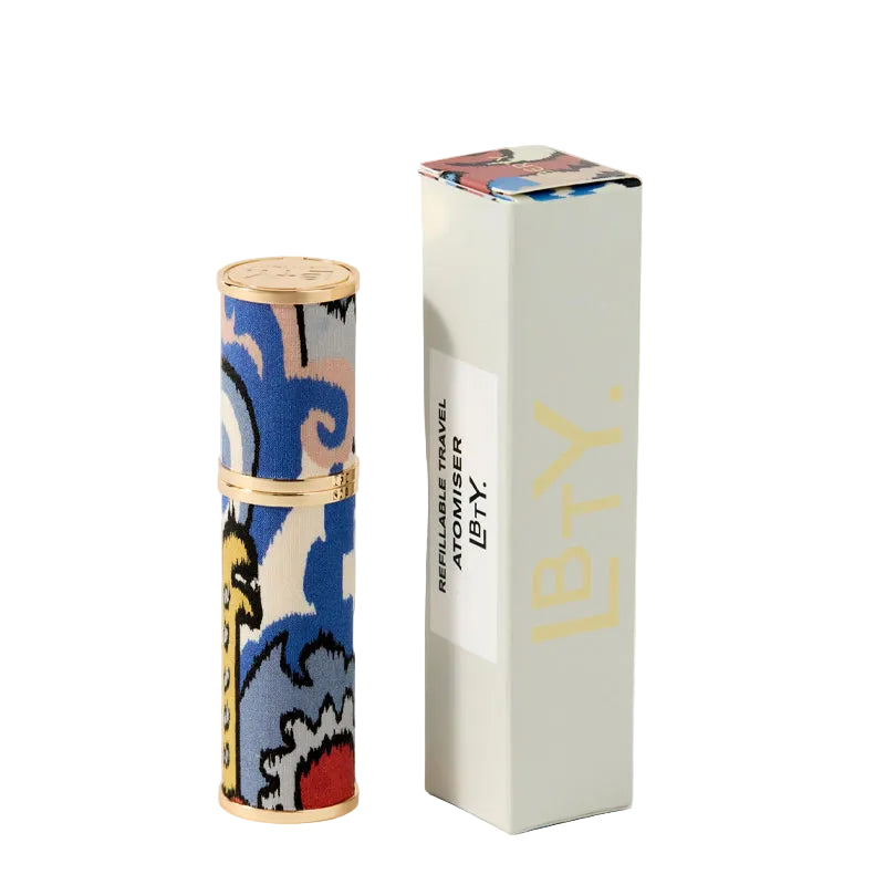 Liberty Beauty's colorful cylindrical travel atomizer that is refillable with a patterned design on a white background. The box is next to it.