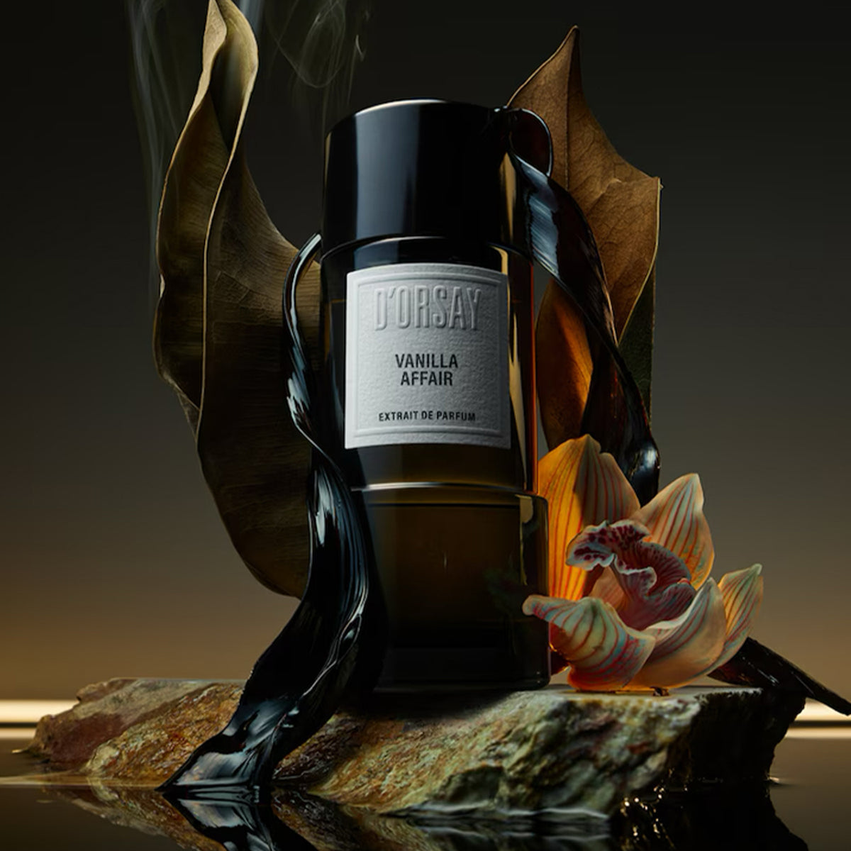 A black flacon by D'Orsay sitting on a marble rock surrounded by leaves and an orchid.  Vanilla Affair Extrait de Parfum. 3oz