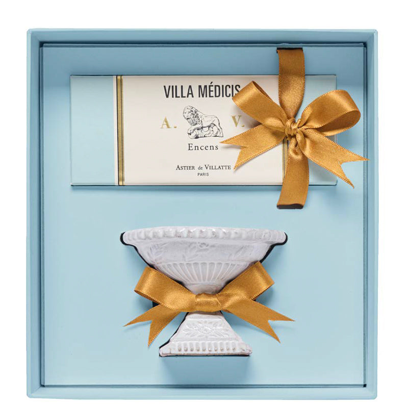 A gift box including Astier de Villattes Villa Medici incense box and a incense holder in white ceramic.  the two items are presented in a light blue box with a gold ribbon attached around the incense and the holder.