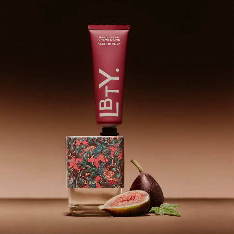 Hand cream tube with floral design base and figs on a brown background. Zephirine - Hand Cream | Liberty Beauty | AEDES.COM